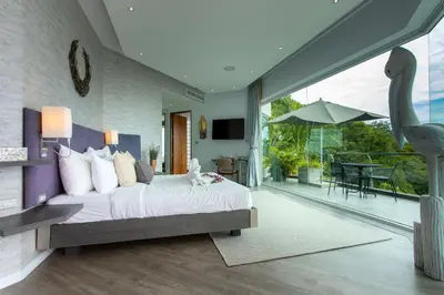 a bedroom with a large bed and a balcony at Villa Namaste 7 Bedroom Fully Staffed Seaview Villa in Bang Tao Beach