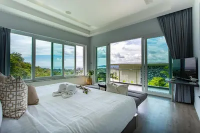 a bedroom with a large white bed and large windows at Villa Namaste 7 Bedroom Fully Staffed Seaview Villa in Bang Tao Beach