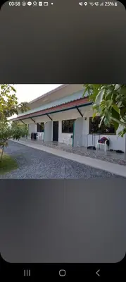 a white building with tables and chairs in front of it at Teahouse in Phuket Town
