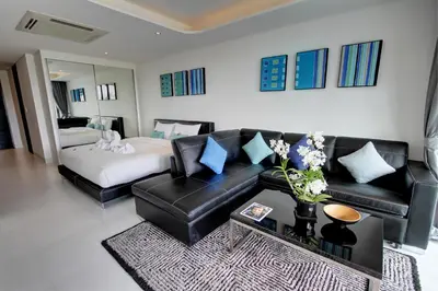 a living room with a couch and a bed at Lets Phuket Twin Sands Resort & Spa in Patong Beach