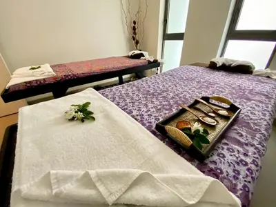a table with a tray of food on a bed at Lets Phuket Twin Sands Resort & Spa in Patong Beach