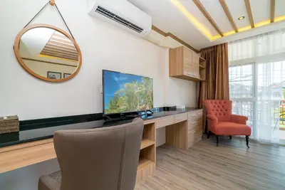 a room with a desk with a television and a chair at Phuket9 Residence in Chalong