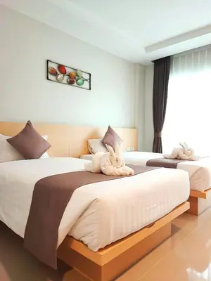 a bedroom with two beds with towels on them at The Beach at Klong Muang in Klong Muang Beach