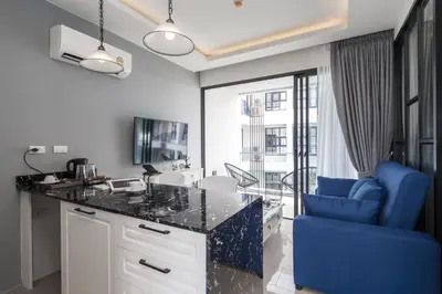 a kitchen with a desk and a blue chair at Palmyrah Surin Beach Residence in Surin Beach