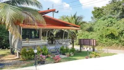 a house with a porch with a bench and flowers at ฺBankunyaiy Resort in Ko Yao Yai