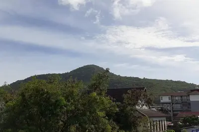 a mountain in the distance with houses and trees at Praew Mansion in Kamala Beach