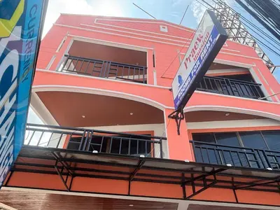 a pink building with a sign in front of it at Praew Mansion in Kamala Beach