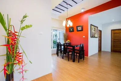 a dining room with a table and a red wall at Irawan House in Ao Nang Beach