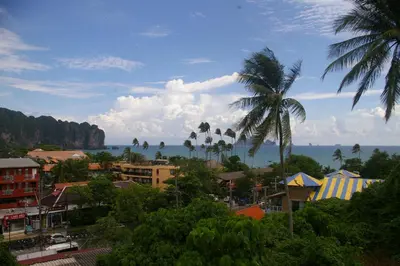 a city with a palm tree and the ocean at Aonang Inn in Krabi town