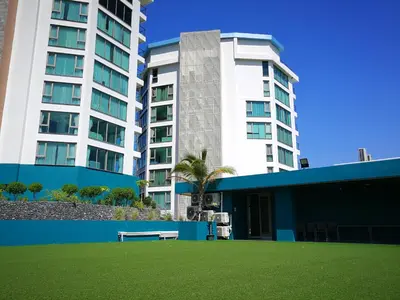 a park in front of two tall buildings at Luxury Lagoon 1bedroom Apartment in Kamala Beach