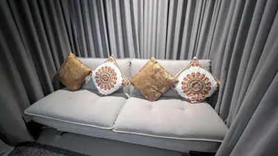 a white couch with four pillows on it at Relife Windy by Nataly in Phuket Town