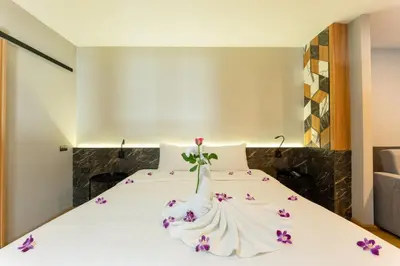 a bedroom with a bed with purple flowers on it at Sky Wave Patong in Patong Beach