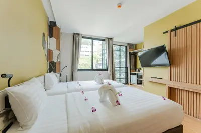 a bedroom with a large white bed with stuffed animals on it at Sky Wave Patong in Patong Beach