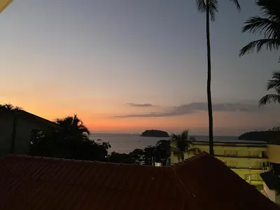 a view of the ocean at sunset from a house at Kata White Villas in Kata Beach