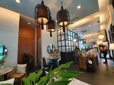 a person sitting at a table in a room with lights at Beautiful 3 bedroom pool villa with 65inch smart tv Located near popular Bangtao beach and laguna Phuket in Bang Tao Beach