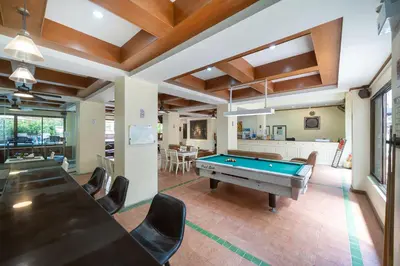 a living room with a pool table and chairs at Patong Central Residence and Apartment in Patong Beach