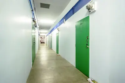 a row of green doors in a hallway at Baan Kim Lian SHA in Phuket Town