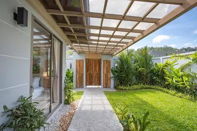 a pergola over the front door of a house at Beach escape at Villa Dalaa 8 in Kamala Beach