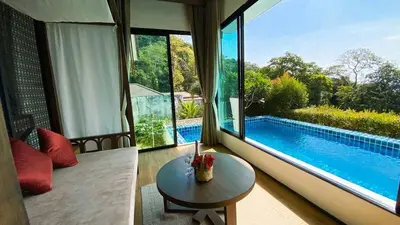 a living room with a table and a swimming pool at Silla Villa Private Pool & Sea View in Kata Beach