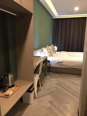 a hotel room with a bed and a desk in a room at Yanud Residence in Phuket Town