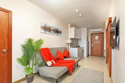 a living room with a couch with a red blanket at Palmetto by Holy Cow, 2-BR, Sea View in Karon Beach