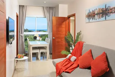a living room with a couch and a table at Palmetto by Holy Cow, 2-BR, Sea View in Karon Beach