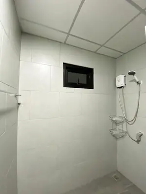 a bathroom with a shower and a television on the wall at Nai Yang Residence in Nai Yang Beach