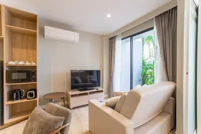 a living room with two chairs and a television at 1bdr Pool Access Apartment Bangtao #5103 in Bang Tao Beach