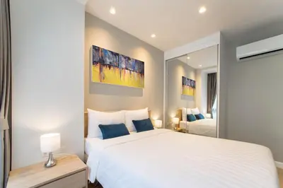 a bedroom with a large white bed and a mirror at 1bdr Pool Access Apartment Bangtao #5104 in Bang Tao Beach