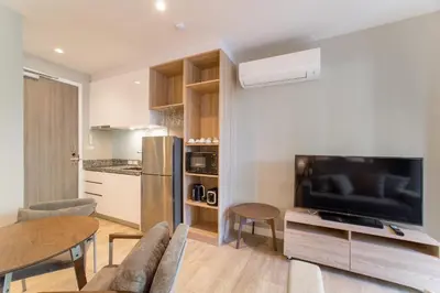a living room with a couch and a tv and a table at 1bdr Pool Access Apartment Bangtao #5104 in Bang Tao Beach