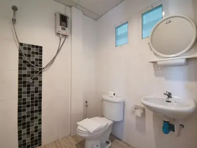 a bathroom with a toilet and a sink and a mirror at Serene Villa Phuket in Chalong