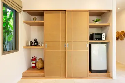 a kitchen with wooden cabinets and a window at Private Resort Boutique Pool Villa Dalaa 5 , near Kamala Beach in Kamala Beach