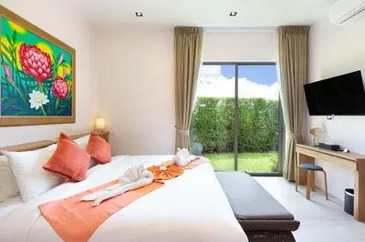 a hotel room with a bed and a tv at Private Resort Boutique Pool Villa Dalaa 5 , near Kamala Beach in Kamala Beach