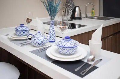 a kitchen counter with blue and white dishes and wine glasses at NARA Condo 1BR Pool View NBC Nai Harn in Nai Harn Beach