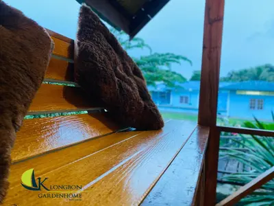 a close up of a wooden bench with water on it at KLONGBON GARDEN HOME Koh Yao Yai in Ko Yao Yai