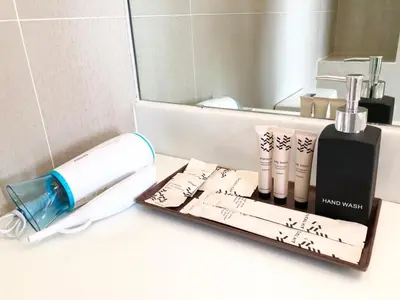a bathroom counter with a mirror and some products on it at Aristo Resort Surin Beach K02 in Surin Beach