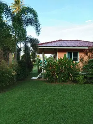 a house with a green lawn in front of it at Baan Kebsap บ้านเก็บทรัพย์ in Ko Yao Noi