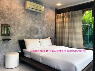 a bedroom with a bed and a window at Cafe'@luv22 in Phuket Town