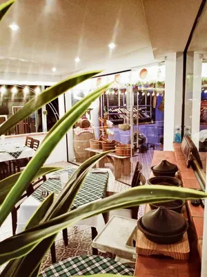 a plant in a room with tables and chairs at La Capannina Hotel Patong in Patong Beach