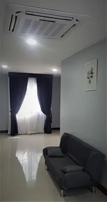 a living room with a couch in front of a window at La Capannina Hotel Patong in Patong Beach