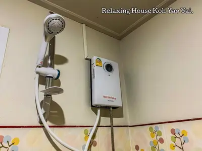 a bathroom with a hair dryer on the wall at Relaxing House Koh Yao Yai in Ko Yao Yai