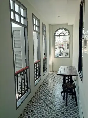 a hallway with a table and some windows at Capzule Bed Phuket in Phuket Town