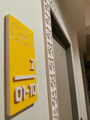 a yellow sign on the side of a door at Capzule Bed Phuket in Phuket Town