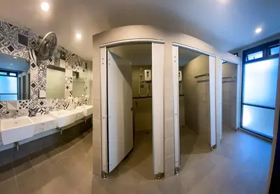a bathroom with two sinks and two mirrors at Capzule Bed Phuket in Phuket Town