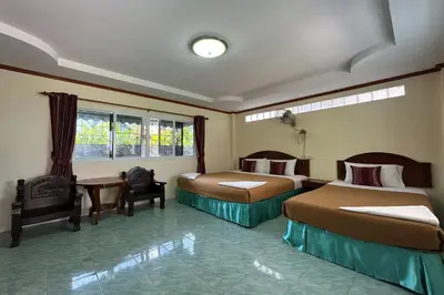 a hotel room with two beds and a chair at Me Mee Place & Tour Krabi in Ao Nang Beach