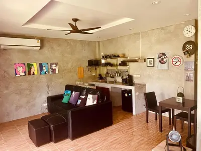 a living room with a couch and a ceiling fan at Destination39 in Thalang