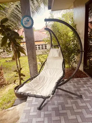 a swing chair with a pillow on a patio at Destination39 in Thalang