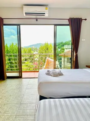 a hotel room with two beds and a balcony at My Friend's House Karon in Karon Beach