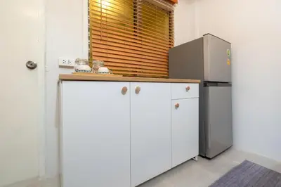a kitchen with white cabinets and a refrigerator at Bangla house with 4 houses Pick house before BOOK in Patong Beach