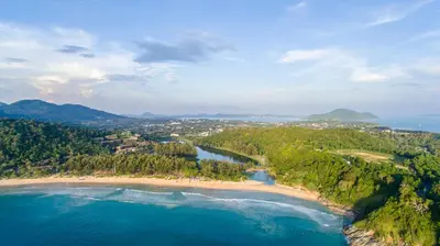 an aerial view of a beach and the ocean at NaiHarn Sea Condo by Holy Cow, 1-BR, mountain view in Nai Harn Beach